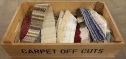 wooden box filled with different coloured carpet offcuts